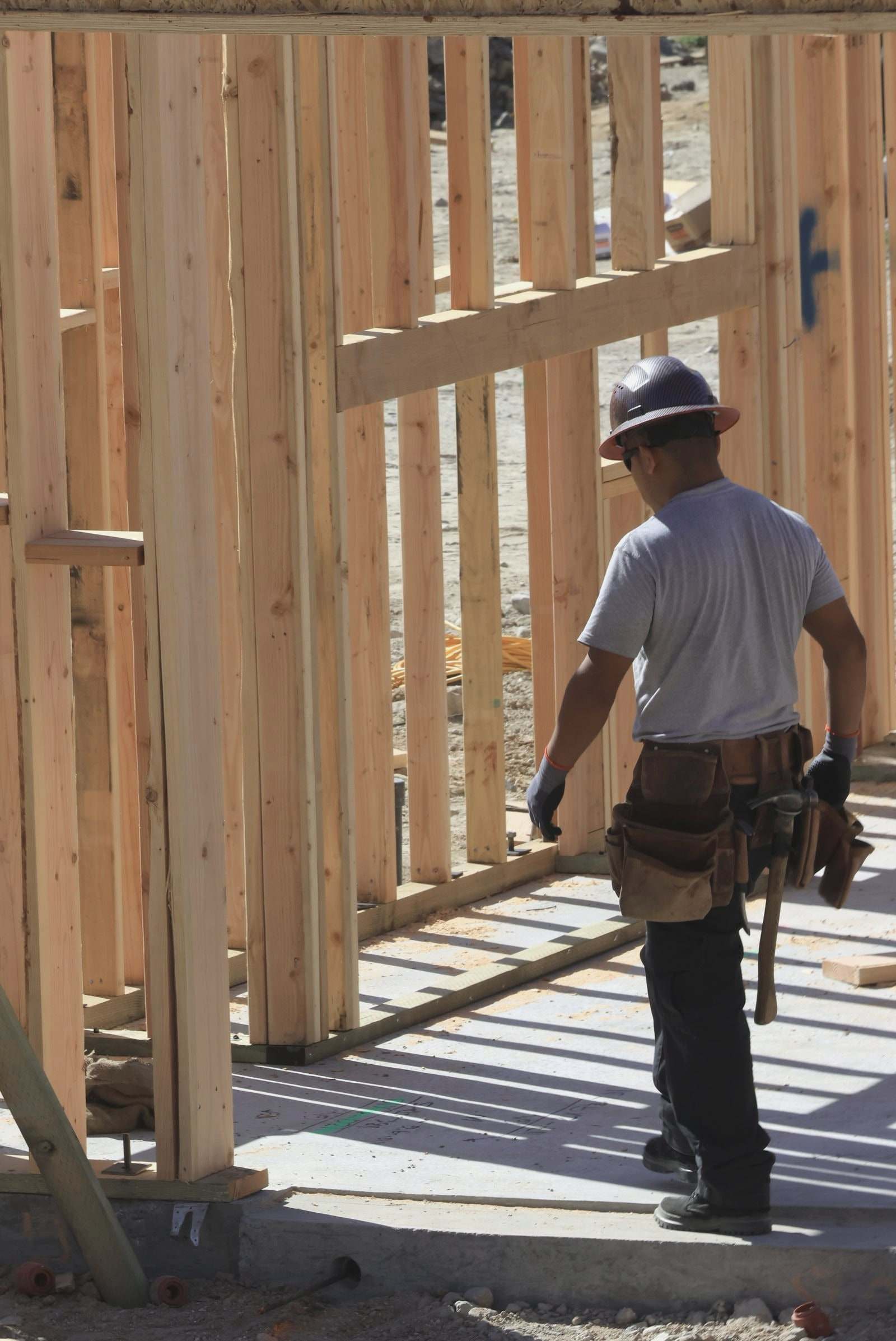 A carpenter framing a house on a job site