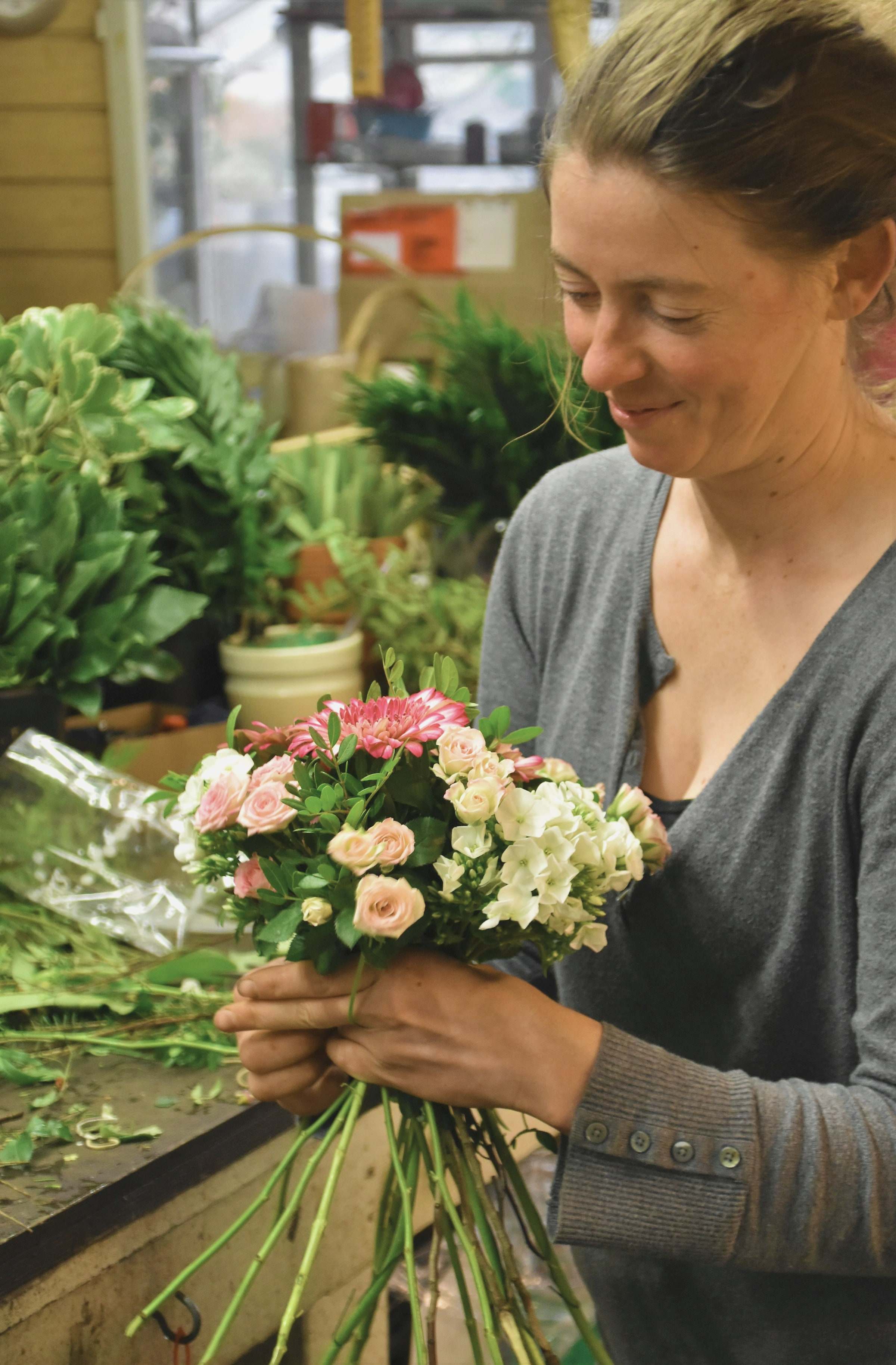 A florist finishing a bouquet in her workroom